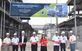 Kok (fourth right), Ling (on her right) and others cut the ribbon to declare open the plant.