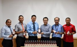 Wong (third right) hands over bottles of Merris Natural Vegetable Oil(Classic) and 2kg Merris Pure Vegetable Oil to Yong while others look on.