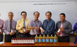 Liew (third left) receives the donation of cooking oil from Ch'ng while others holding a bottle each.