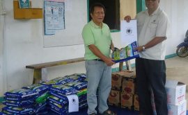 Penghulu Luhat (left) receives the food donation from Crennell on behalf of the Penan community